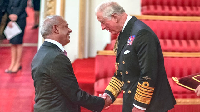 Park Garage Group director Balraj Tandon receives his MBE from Prince Charles
